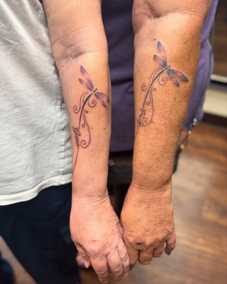 Matching delicate dragonfly tattoos with fine line script on the forearm, featuring a minimalist design in color — by Sandra Price, los angeles