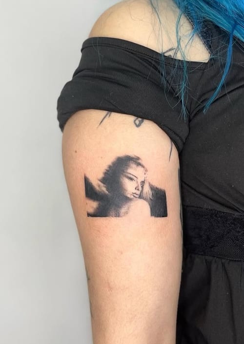 A black and grey realism portrait of a woman on the upper arm, featuring fine detail and soft shading — by Level tattoo, los angeles