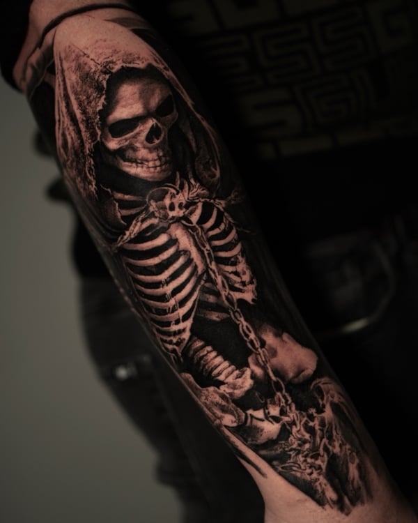 A realistic black and grey tattoo of a skeleton in a hood on the forearm, featuring detailed shading and a dark theme — by Vladimir Kozachenko, los angeles
