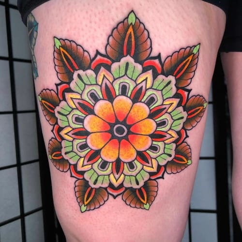 A colorful mandala tattoo on the thigh featuring floral patterns with vibrant orange, green, and yellow hues — by Megan Rose, los angeles