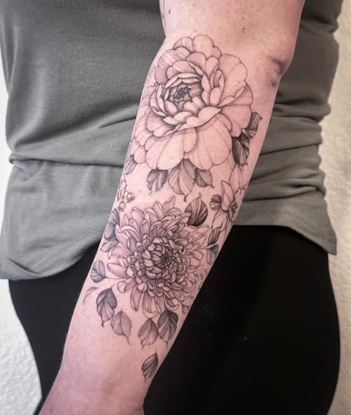 A delicate black and grey floral tattoo on the forearm featuring detailed fine line work — by Melanie Benoit, los angeles