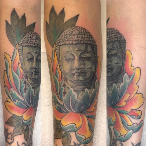 A colorful Buddha head with a lotus flower tattoo on the forearm, done in a neo-traditional style with mixed colors — by Sandra Price, los angeles