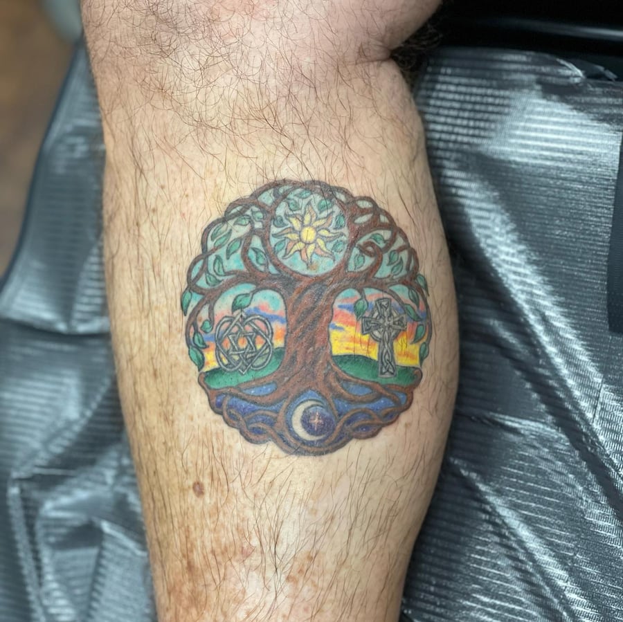 A colorful Celtic tree of life tattoo on the calf, featuring sun and moon symbols with intricate knotwork — by Sandra Price, los angeles