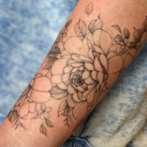 A delicate black and grey floral tattoo on the forearm with fine line detailing and intricate shading — by Melanie Benoit, los angeles