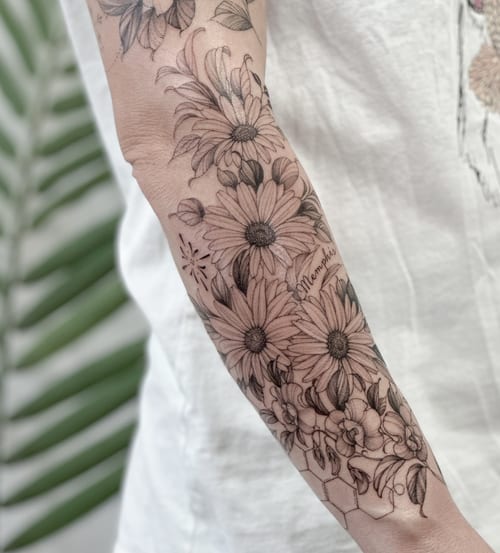 A delicate black and grey floral arrangement tattoo on the forearm with fine line detailing — by Melanie Benoit, los angeles