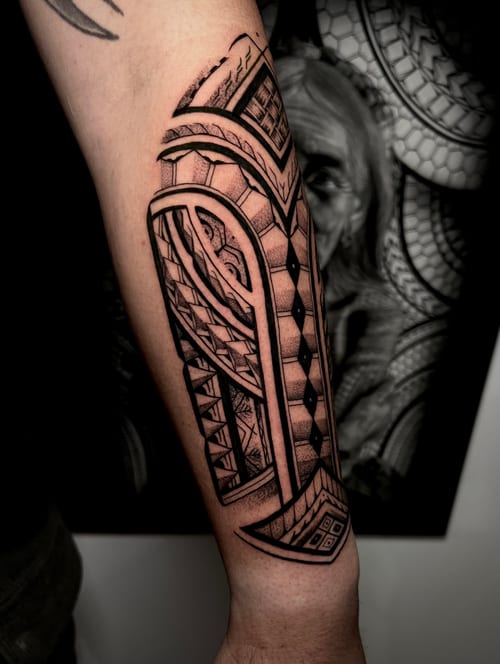 A black and grey Polynesian-style tattoo on the forearm featuring intricate geometric patterns and bold blackwork — by imindisoul, los angeles