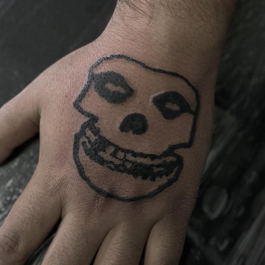 A bold blackwork skull tattoo on the hand with minimalist design — by Maddie Ramirez, los angeles