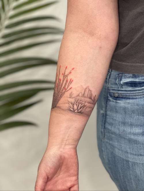 A delicate fine line desert landscape tattoo on the forearm with minimal color accents and detailed plant depiction — by Melanie Benoit, los angeles