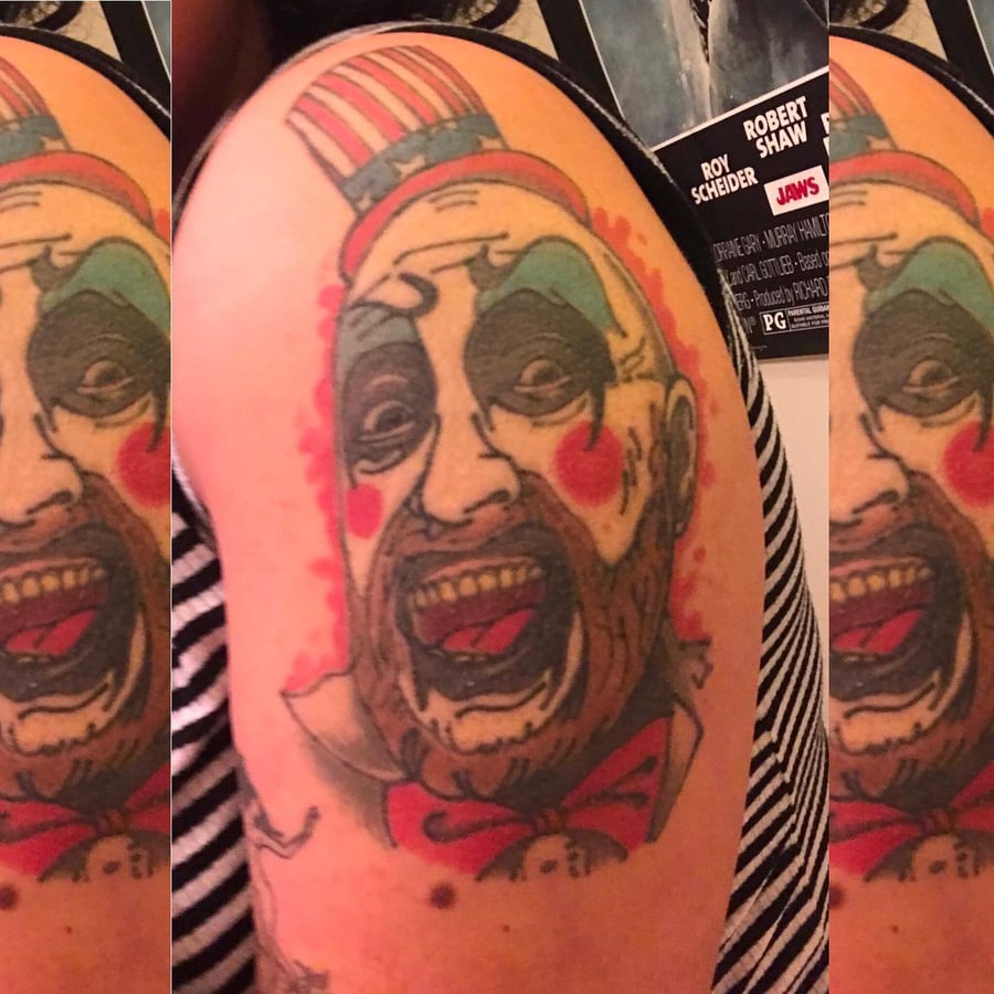 A colorful neo-traditional clown portrait tattoo on the upper arm with bold outlines and vibrant colors — by Sandra Price, los angeles