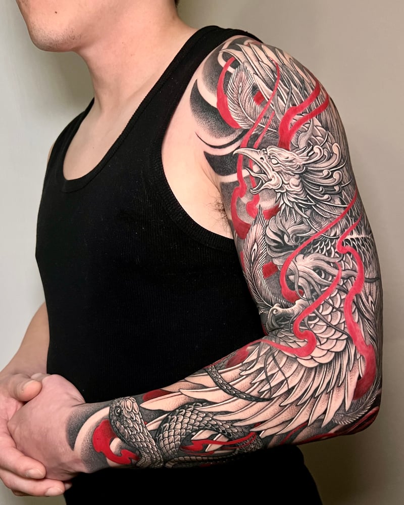 black and grey japanese phoenix sleeve tattoo with red accents and a snake by imindisoul, a japanese tattoo artist in los angeles