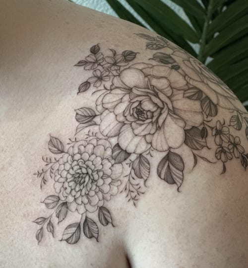 A delicate black and grey floral arrangement tattoo on the shoulder with fine line detailing — by Melanie Benoit, los angeles