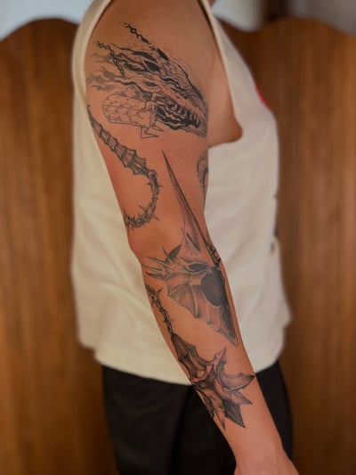 A bold black and grey dragon and armor tattoo on the arm with graphic and illustrative style — by Dylan Aiello, los angeles