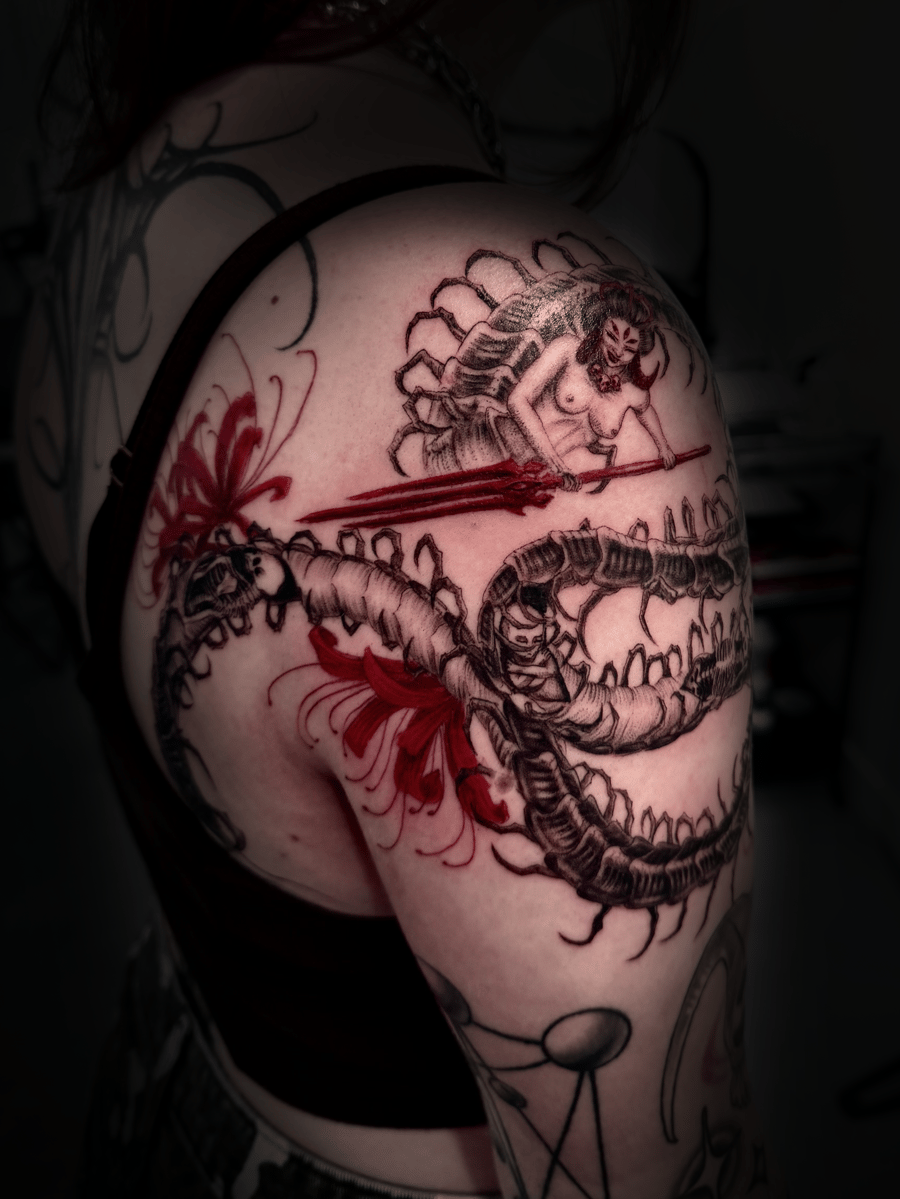 A mixed color tattoo on the shoulder featuring a woman wielding a sword against a dragon, with Japanese and blackwork influences — by zitronxus, los angeles