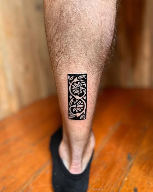 A bold blackwork floral pattern tattoo on the calf, featuring ornamental design elements in a rectangular shape — by Dylan Aiello, los angeles