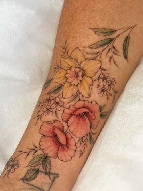 A delicate floral arrangement tattoo on the forearm featuring colorful flowers in a fine line style — by Melanie Benoit, los angeles
