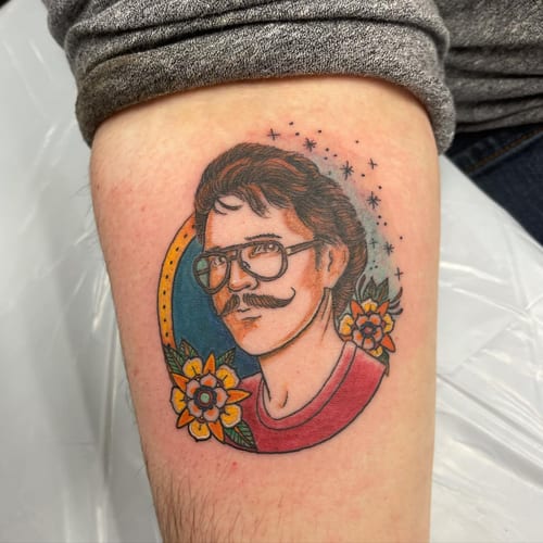 A colorful neo-traditional portrait of a man with glasses and flowers on the thigh, featuring bold outlines and vibrant colors — by Sandra Price, los angeles