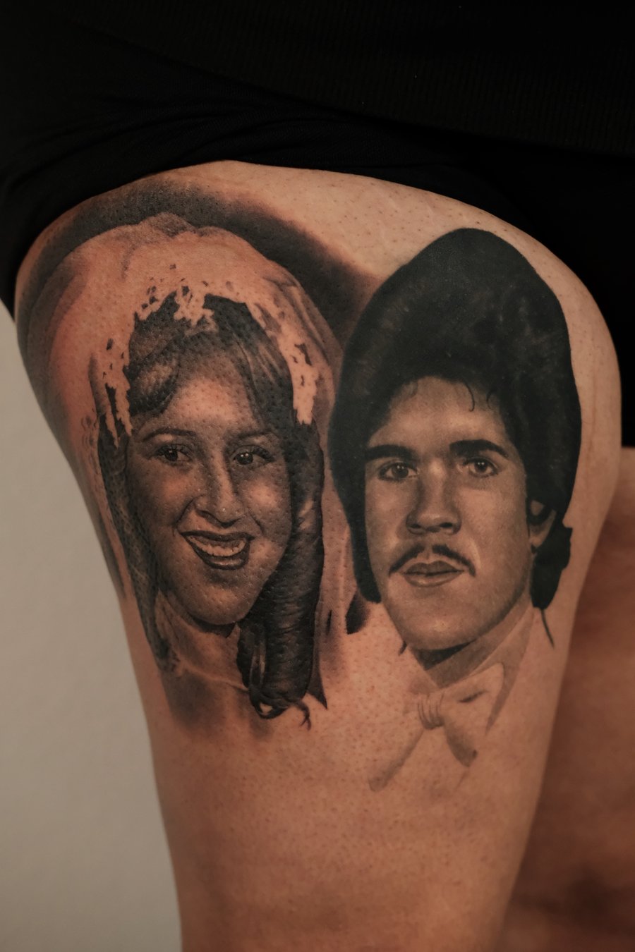 A black and grey realism portrait of a man and a woman on the thigh, capturing detailed facial features and expressions — by Johnny Ayala, los angeles