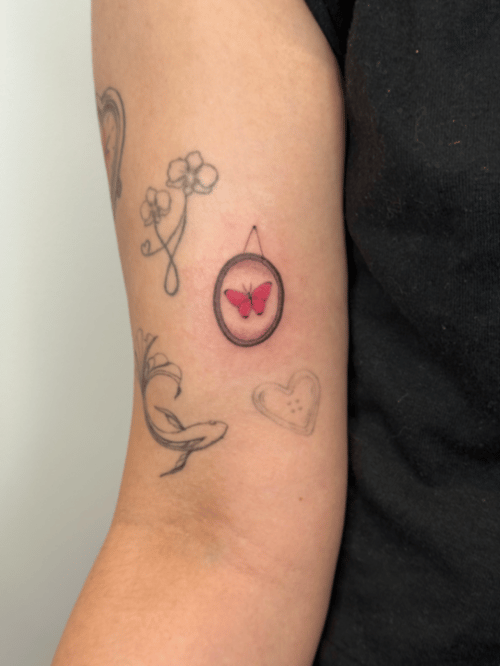 minimalist butterfly in circle tattoo — by Samantha Wilks, los angeles