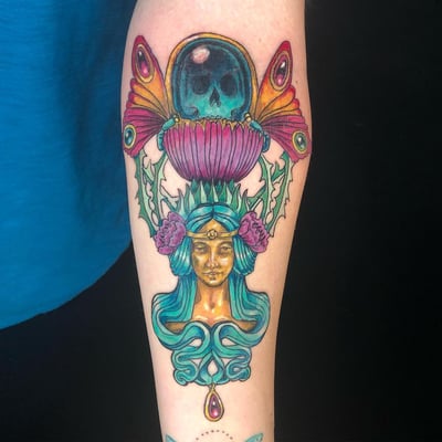 A colorful neo-traditional tattoo on the forearm depicting a woman's face with floral and skull elements in an ornate style — by Sandra Price, los angeles
