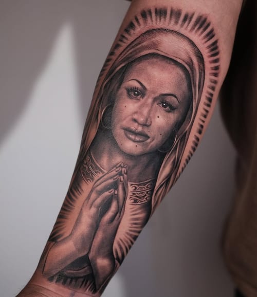A realistic black and grey portrait of a woman with praying hands on the forearm, featuring spiritual and ornate details — by Johnny Ayala, los angeles