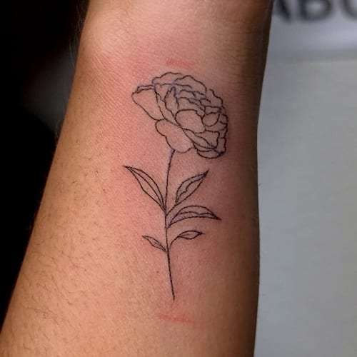 A delicate fine line flower tattoo on the wrist, featuring minimalistic black ink design — by NJ TATTOOZ, los angeles