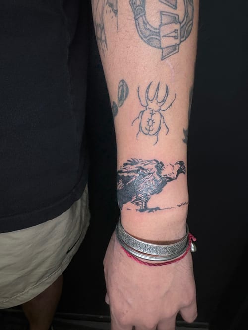 A black and grey linework tattoo of a bird on the wrist, featuring bold outlines and minimal shading — by Hannah , los angeles