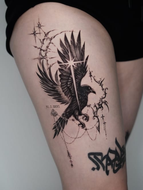 A black and grey tattoo of a raven with a cross and chains on the thigh, featuring detailed illustrative elements — by Jian Liang, los angeles