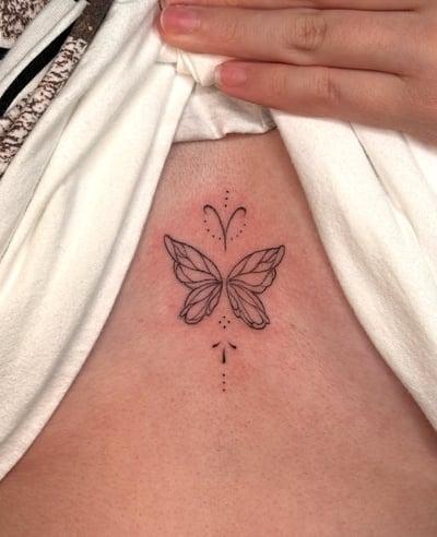 A minimalist fine line butterfly tattoo on the sternum with delicate dotwork accents in black ink — by NJ TATTOOZ, los angeles