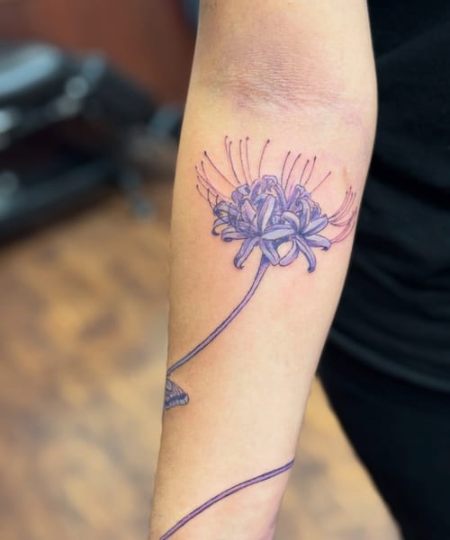 A delicate fine line purple flower tattoo on the forearm, showcasing a botanical design with intricate details — by Sandra Price, los angeles