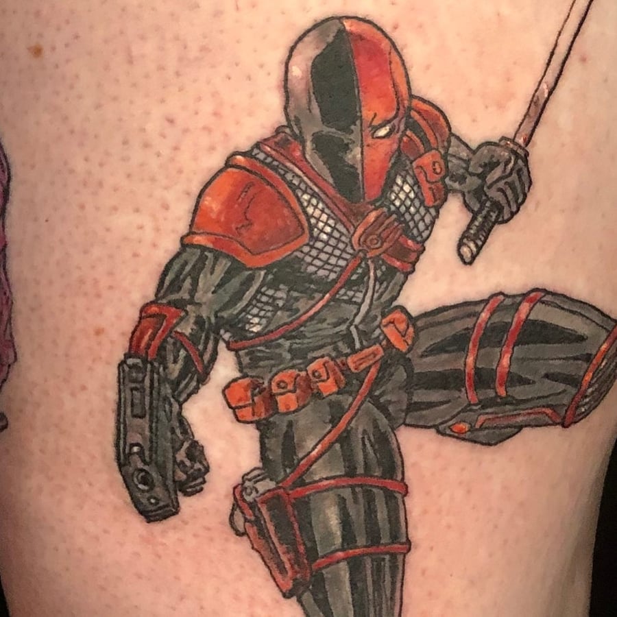 A bold and colorful tattoo of a comic book character in armor holding a sword, featuring strong graphic lines and vibrant colors — by Sandra Price, los angeles