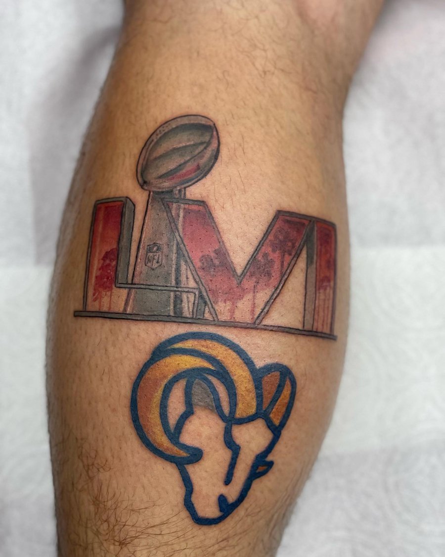 A colorful tattoo featuring the Super Bowl trophy and Rams logo on the leg, done in an illustrative style — by Sandra Price, los angeles