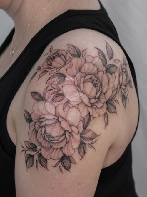 A delicate black and grey flower bouquet tattoo on the shoulder with intricate shading and detail — by Melanie Benoit, los angeles