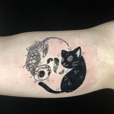 A black and grey yin yang tattoo featuring a cat and a skeleton on the forearm, done in a graphic blackwork style — by Sandra Price, los angeles