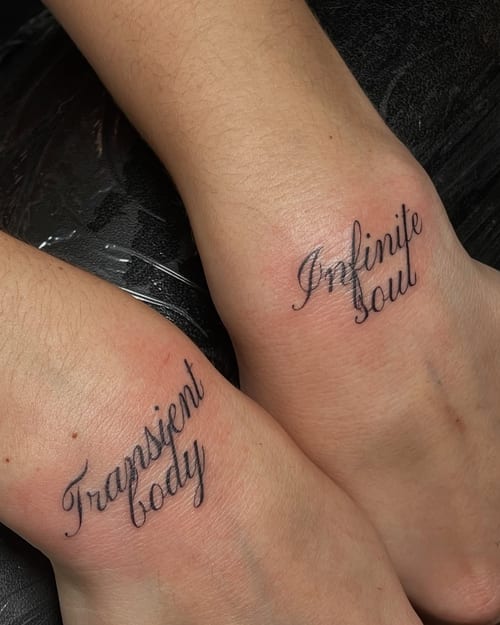 A minimalist black script lettering tattoo on the wrist with the phrases 'Transient body' and 'Infinite soul' — by Level tattoo, los angeles