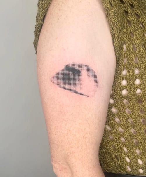 An abstract dotwork tattoo of an eye on the upper arm, using black and grey ink with a pixelated effect — by Level tattoo, los angeles