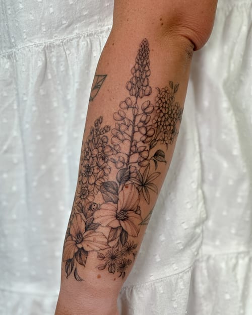 A delicate black and grey floral arrangement tattoo on the forearm, featuring fine line and ornate detailing — by Melanie Benoit, los angeles