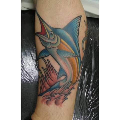 A colorful illustrative tattoo of a swordfish jumping out of the water on the calf — by Samuel Connelly, san diego, ca