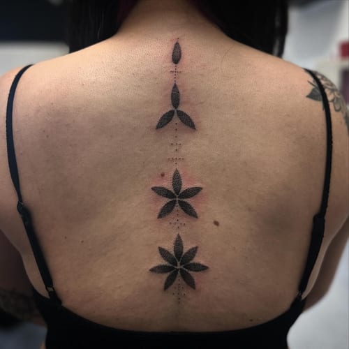 A delicate black and grey dotwork floral design tattoo on the back — by Maddie Ramirez, los angeles