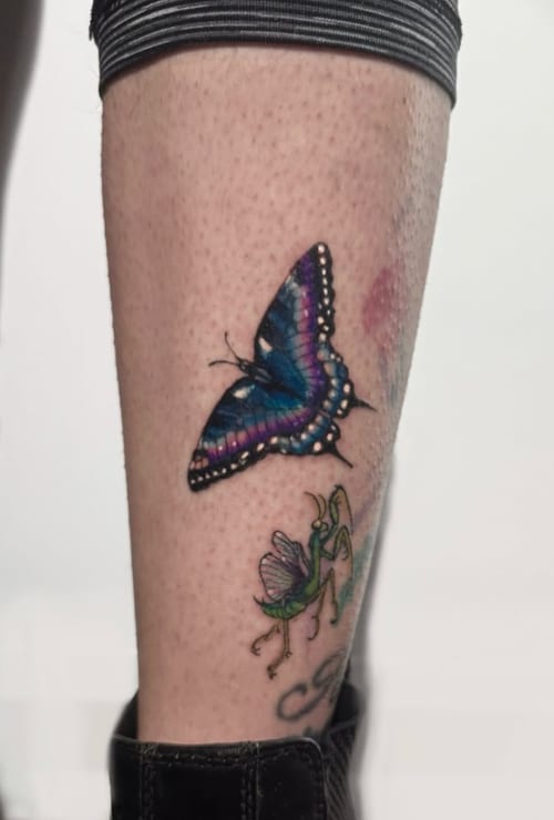 A colorful realism tattoo of a butterfly and a praying mantis on the calf, featuring vibrant blues and greens with detailed shading — by Shelby Bianco, los angeles