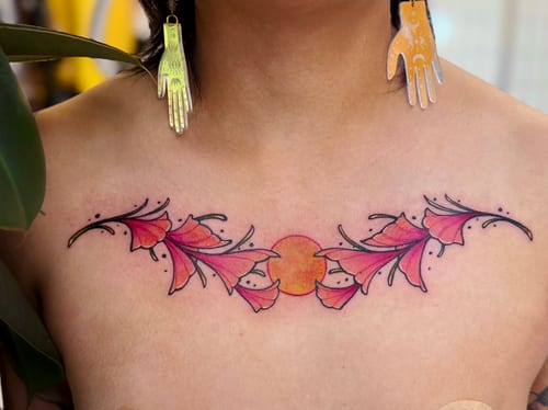 A colorful watercolor floral tattoo on the chest featuring stylized flowers with vibrant pink and orange hues — by Tweetwee, los angeles