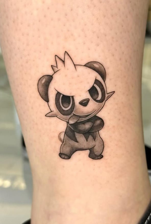 A black and grey anime-style tattoo of Pancham on the leg, featuring bold outlines and shading — by otaybeatdown, orange, ca