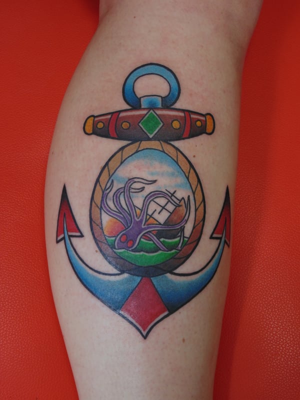 A colorful traditional anchor tattoo on the calf featuring a kraken and ocean theme — by Samuel Connelly, san diego, ca
