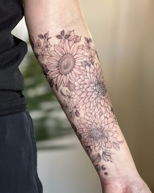 A delicate black and grey floral arrangement tattoo on the forearm featuring detailed flowers and leaves — by Melanie Benoit, los angeles