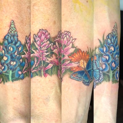 A colorful tattoo of wildflowers and a butterfly on the forearm, featuring realistic details and vibrant colors — by Sandra Price, los angeles