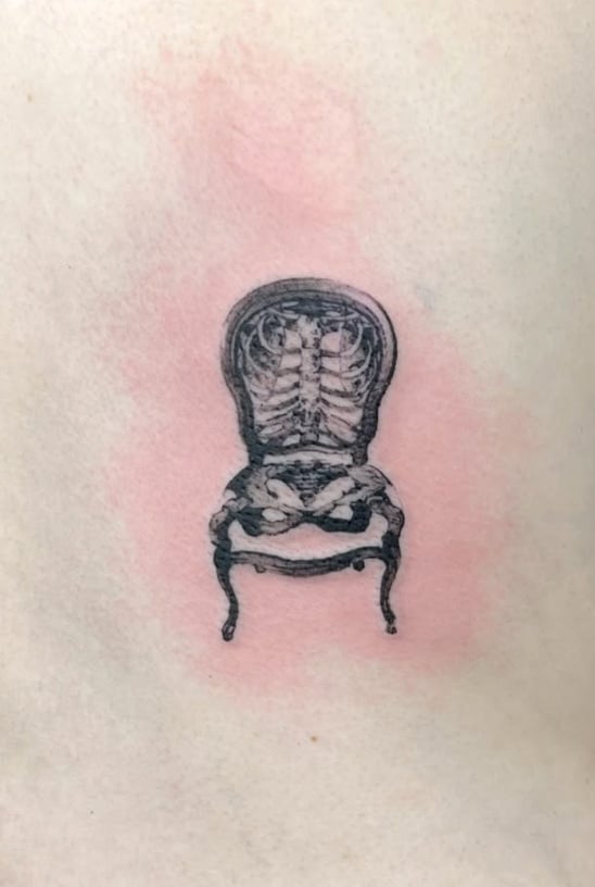 A black and grey surreal tattoo of a chair with a skeleton integrated into its design, featuring detailed linework — by Level tattoo, los angeles