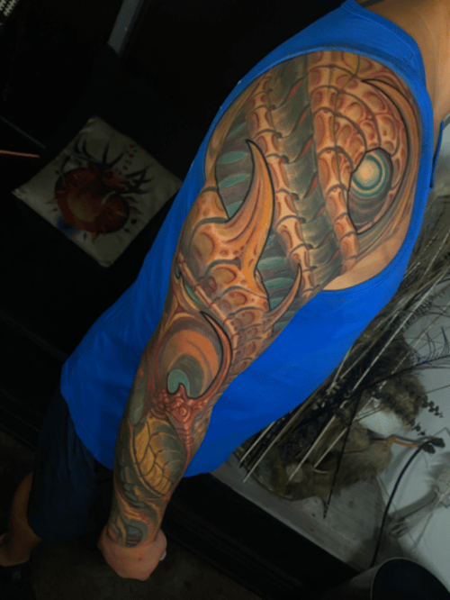 A vibrant full sleeve tattoo featuring a bio-mechanical dragon design with intricate details and bold colors — by tyler_whitlock, los angeles