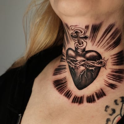 A bold black and grey sacred heart tattoo on the neck, featuring thorns and a cross with radiant lines — by Johnny Ayala, los angeles