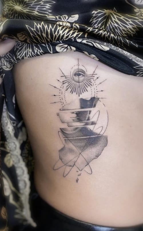 An abstract black and grey tattoo on the rib featuring an eye with geometric and sacred geometry elements, incorporating fine lines and shading — by Jian Liang, los angeles