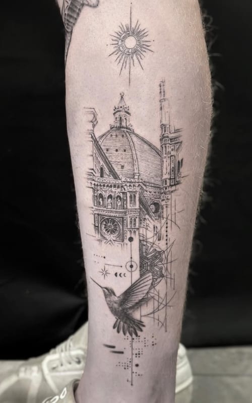 A black and grey fine line tattoo on the calf depicting an architectural structure with geometric elements, a bird, and a sun above — by Jian Liang, los angeles