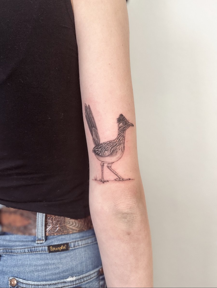 A delicate black and grey bird tattoo on the forearm, featuring an illustrative style with fine line details — by Melanie Benoit, los angeles